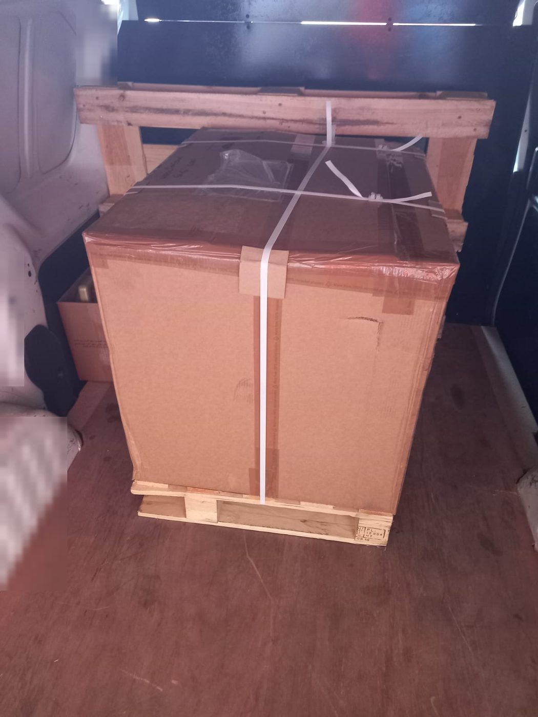 A wooden crate strapped to a pallet, ready for transport.