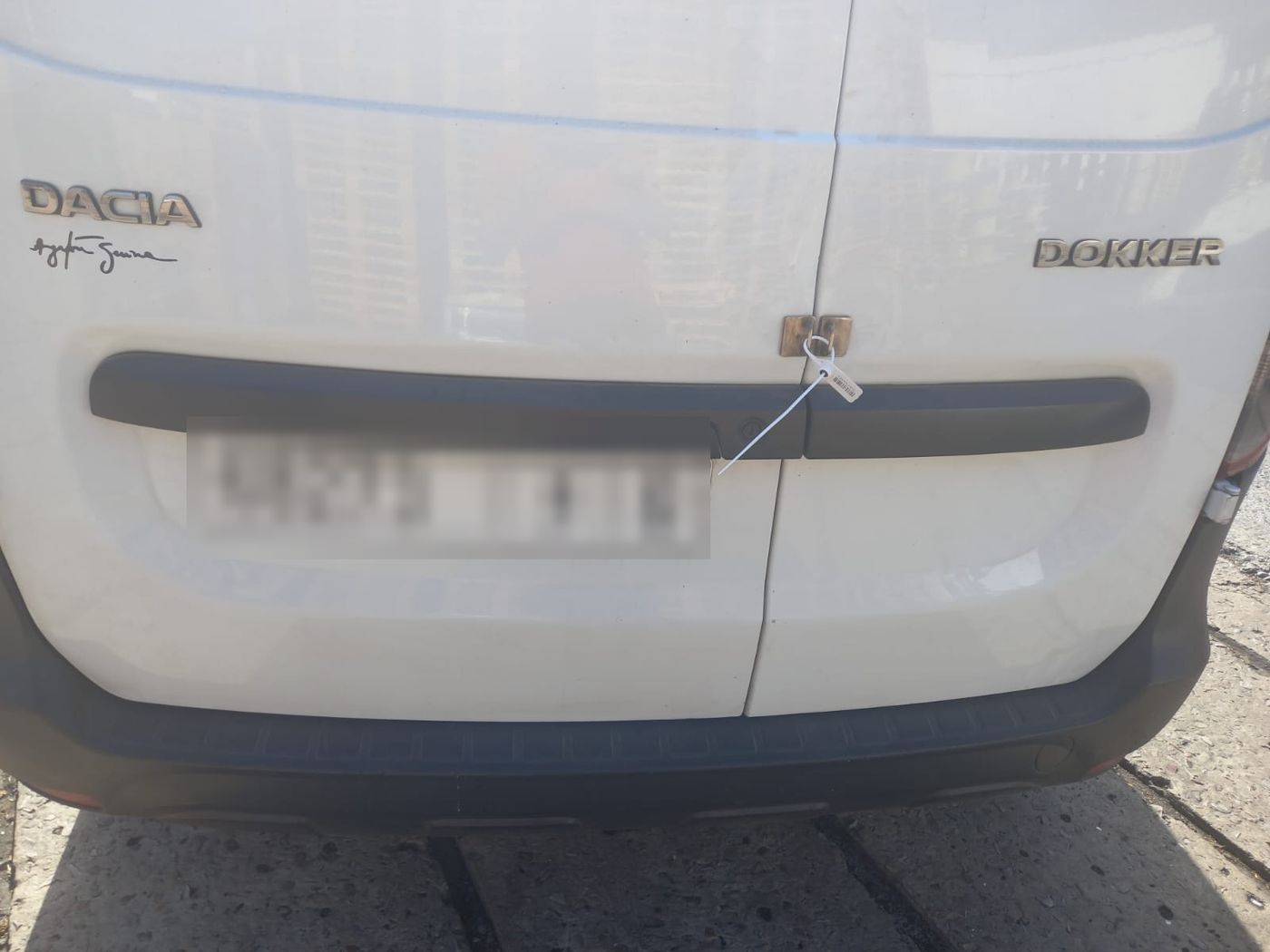 The rear door of a delivery van closed with a numbered customs seal.